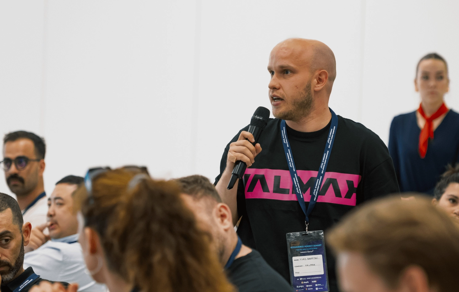 Man with mic in Valmax t-shirt at conference