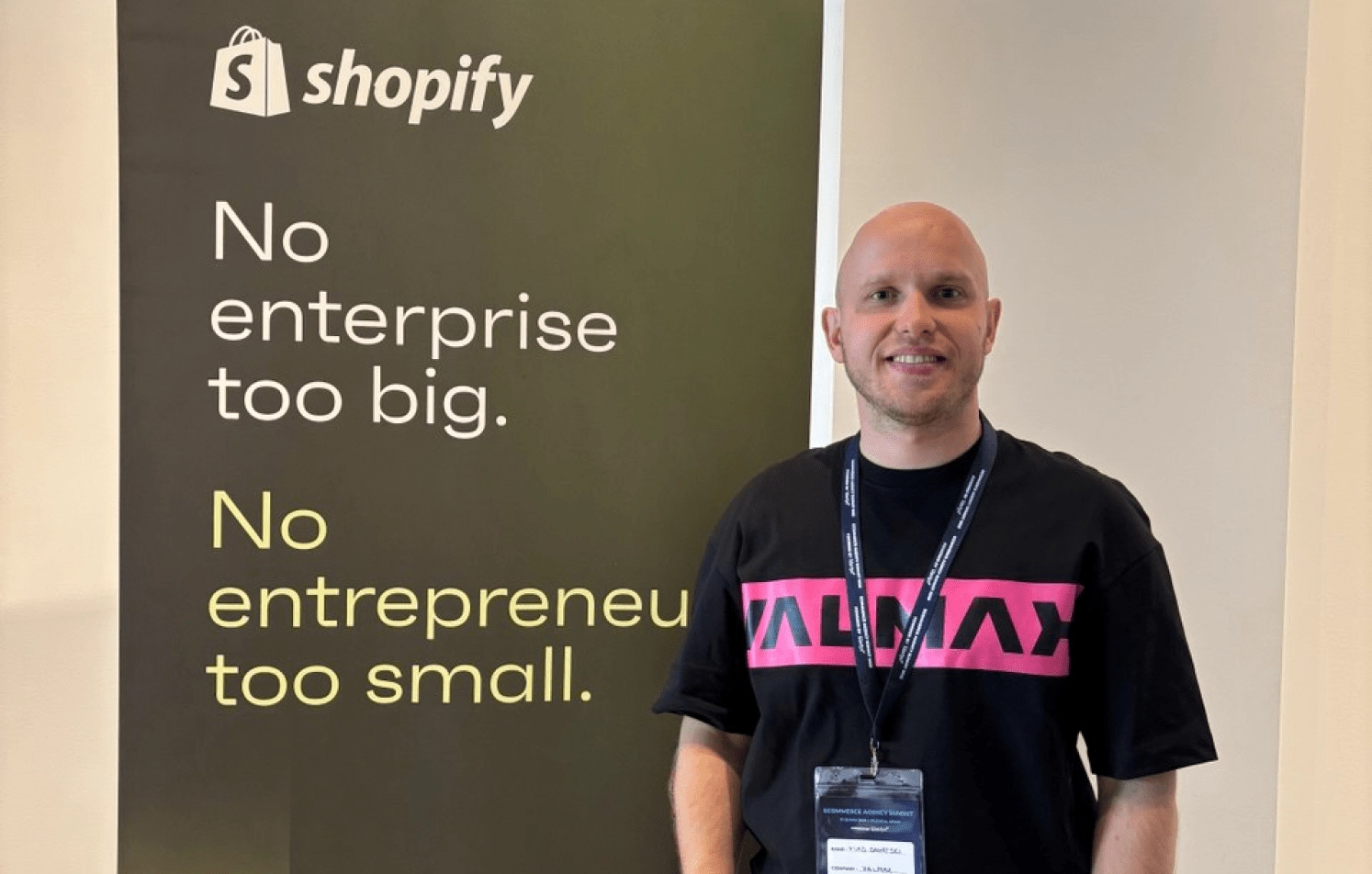 Man next to Shopify banner in Valmax t-shirt.