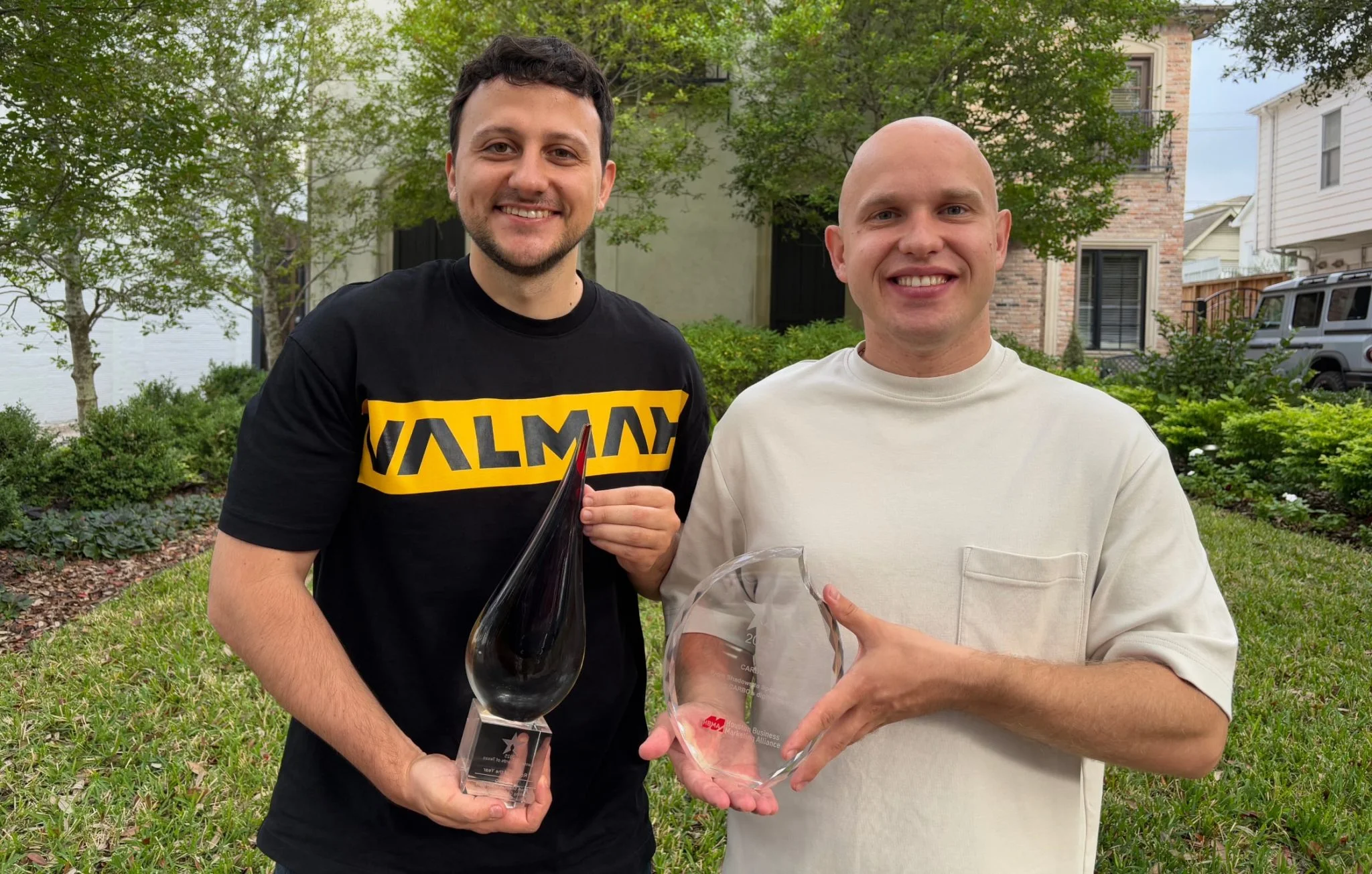 Two men holding awards